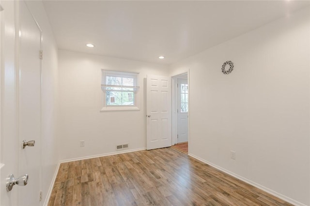 unfurnished room featuring recessed lighting, wood finished floors, and baseboards