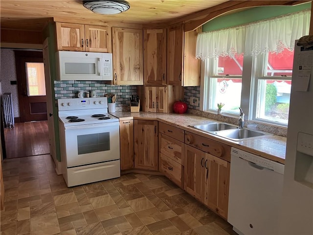 kitchen with a sink, white appliances, wood ceiling, light countertops, and backsplash