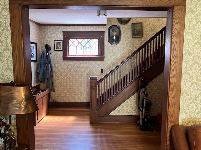 stairs featuring wallpapered walls, baseboards, and wood-type flooring