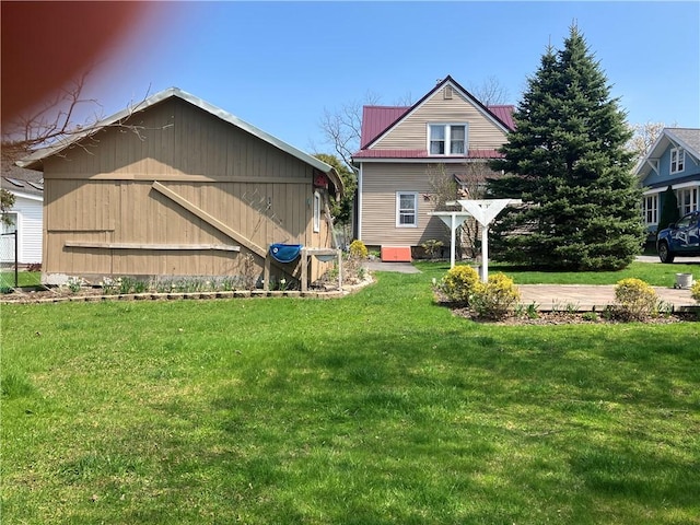 back of house featuring a yard and metal roof