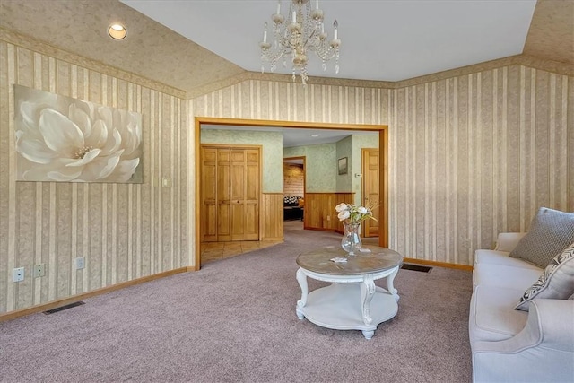 carpeted living area with wallpapered walls, visible vents, and an inviting chandelier