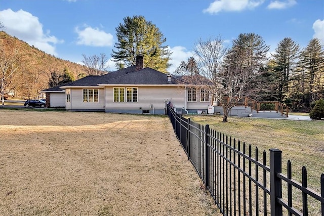 back of property featuring a chimney, fence, and a mountain view