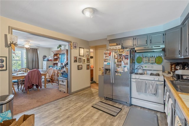 19 Whig Hill Rd, West Monroe, NY 13167 - kitchen featuring white gas range, stainless steel refrigerator with ice dispenser, under cabinet range hood, light countertops, and light wood finished floors