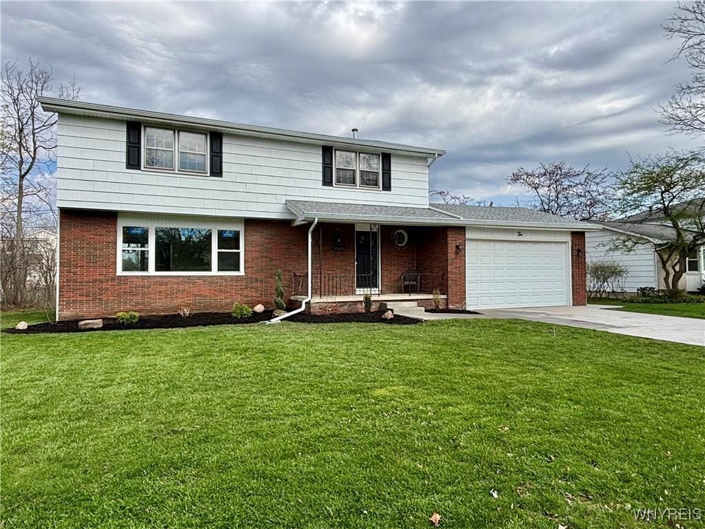 view of front of property with concrete driveway, a front lawn, an attached garage, a porch, and brick siding