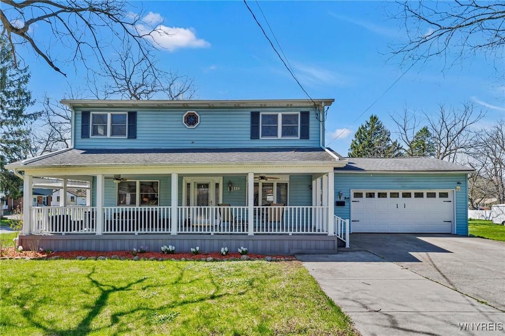 traditional-style home featuring a ceiling fan, a front lawn, an attached garage, driveway, and covered porch