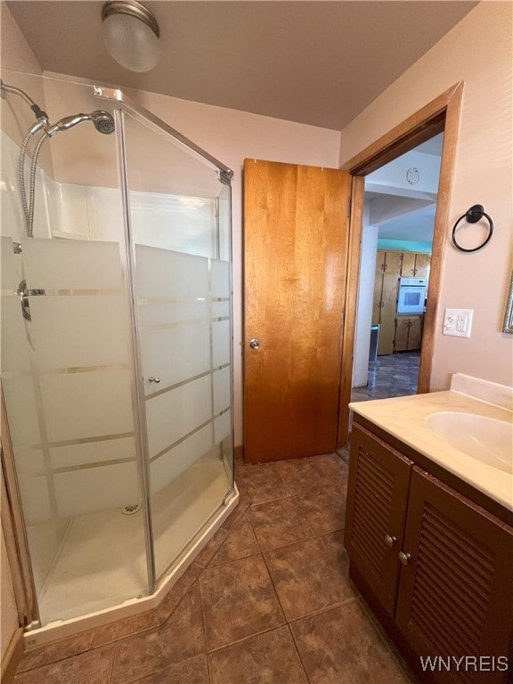 full bathroom with a shower stall, tile patterned flooring, and vanity