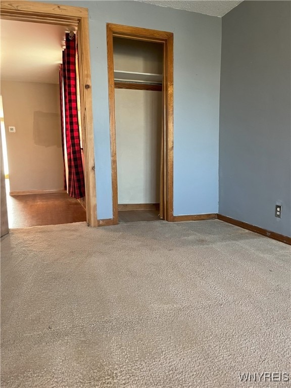 unfurnished bedroom featuring baseboards, a closet, and carpet