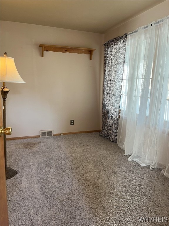 carpeted spare room with baseboards and visible vents