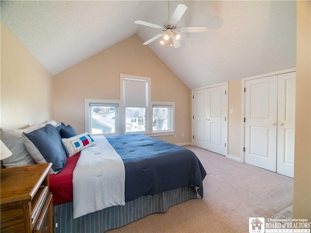 bedroom with carpet flooring, baseboards, lofted ceiling, a ceiling fan, and multiple closets