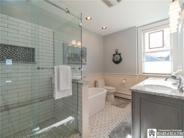 full bath featuring a baseboard heating unit, a shower stall, a wainscoted wall, and visible vents