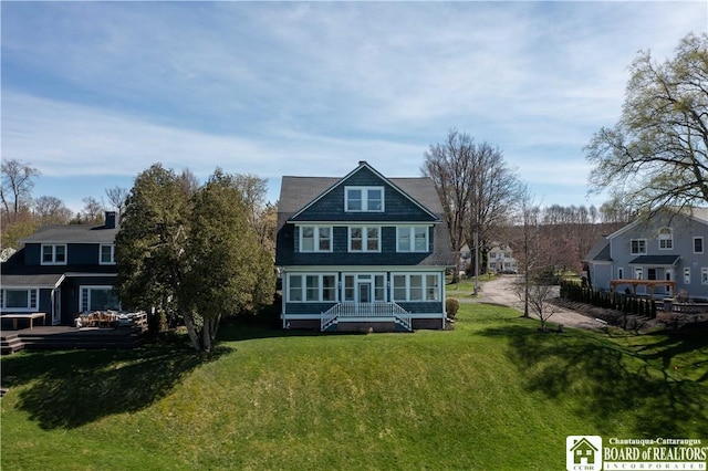 back of house featuring a residential view, a lawn, and covered porch