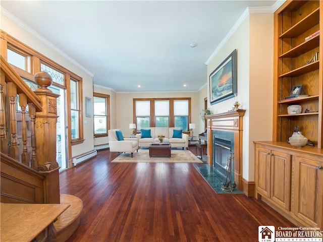 living room with crown molding, a baseboard heating unit, built in shelves, a premium fireplace, and dark wood-style floors