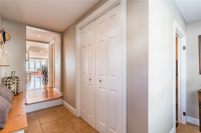 hallway featuring recessed lighting, baseboards, and light tile patterned floors