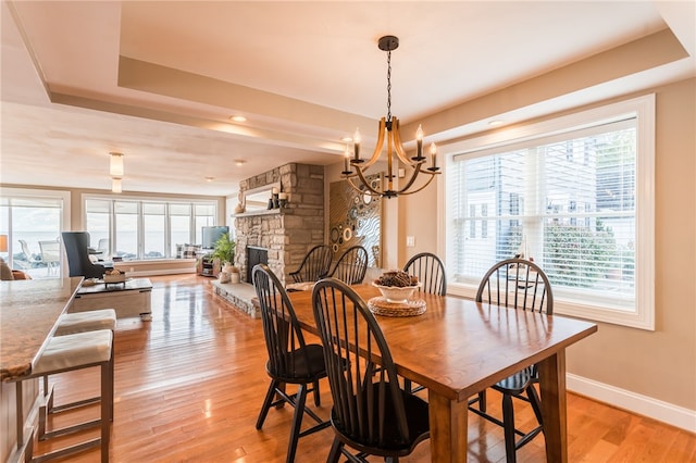 dining room with plenty of natural light, light wood finished floors, and a notable chandelier