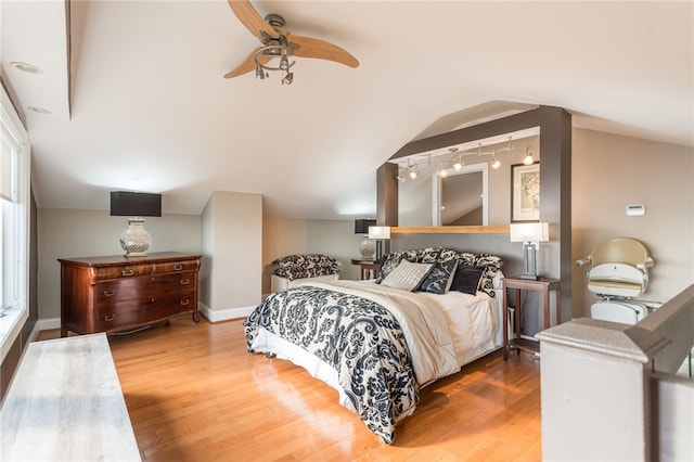 bedroom featuring track lighting, wood finished floors, and ceiling fan