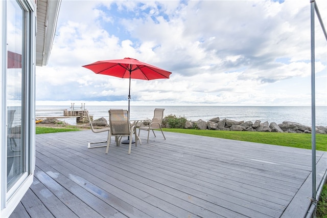 wooden terrace with outdoor dining area and a water view