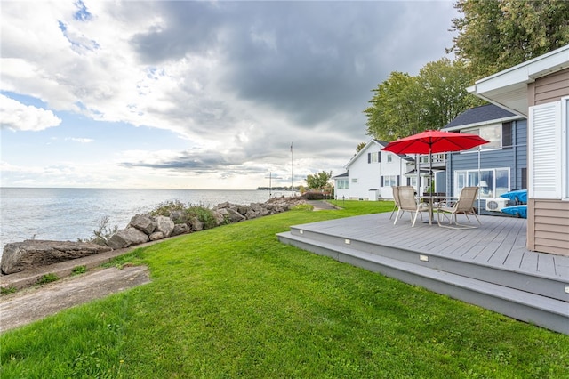 view of yard featuring a deck with water view and outdoor dining space