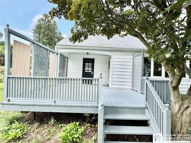 back of house featuring a wooden deck and a shingled roof