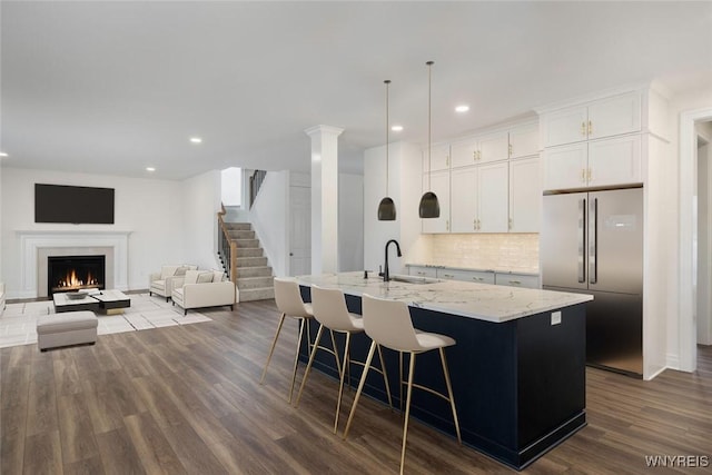 69 Woodthrush Trl, Orchard Park, NY 14127 - kitchen featuring stainless steel refrigerator, a kitchen island with sink, dark wood-type flooring, light stone countertops, and recessed lighting