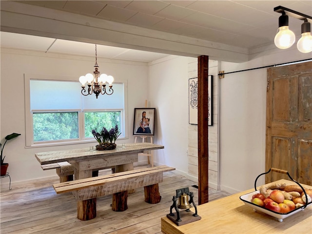 dining space featuring a chandelier, wood finished floors, baseboards, and ornamental molding