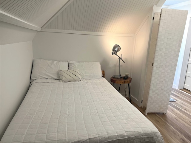 bedroom featuring lofted ceiling and wood finished floors