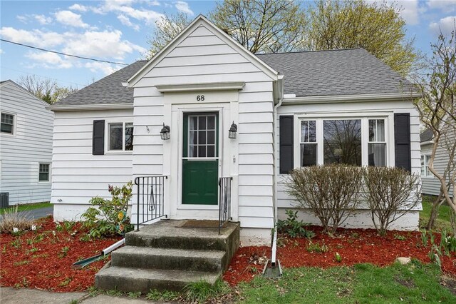 bungalow-style home with roof with shingles
