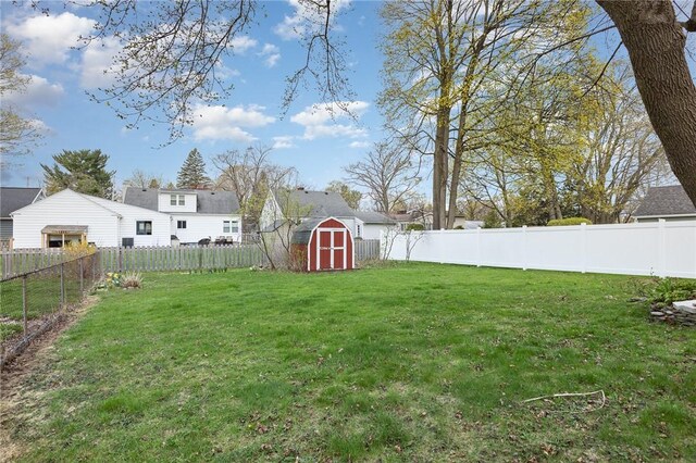 view of yard featuring a fenced backyard, an outdoor structure, and a shed