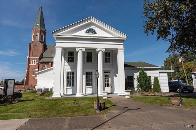 neoclassical / greek revival house featuring a front yard