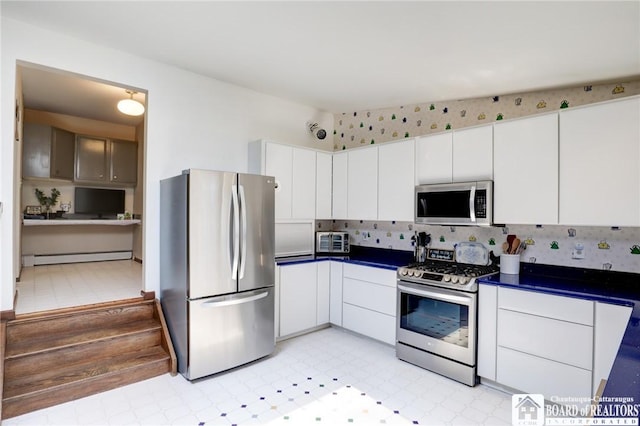 kitchen featuring a baseboard heating unit, appliances with stainless steel finishes, and white cabinetry