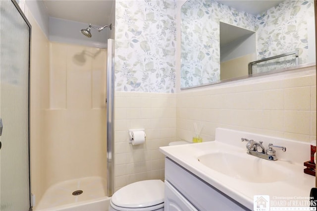 full bath with wallpapered walls, a shower stall, and tile walls