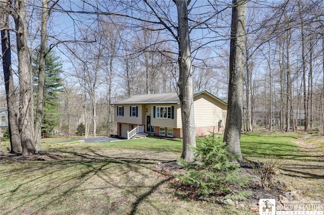 split foyer home with an attached garage and a front lawn