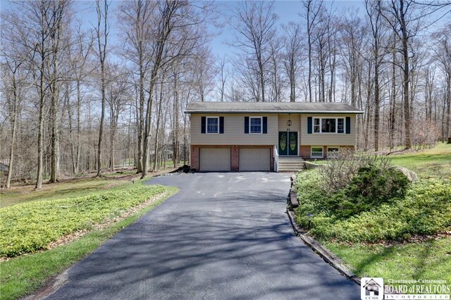 split foyer home with brick siding, driveway, and a garage