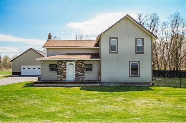 traditional-style home featuring fence, a chimney, a front yard, and a garage