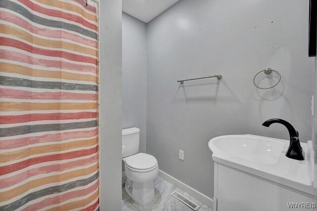 269 S Main St, Wellsville, NY 14895 - full bathroom featuring toilet, baseboards, visible vents, marble finish floor, and vanity