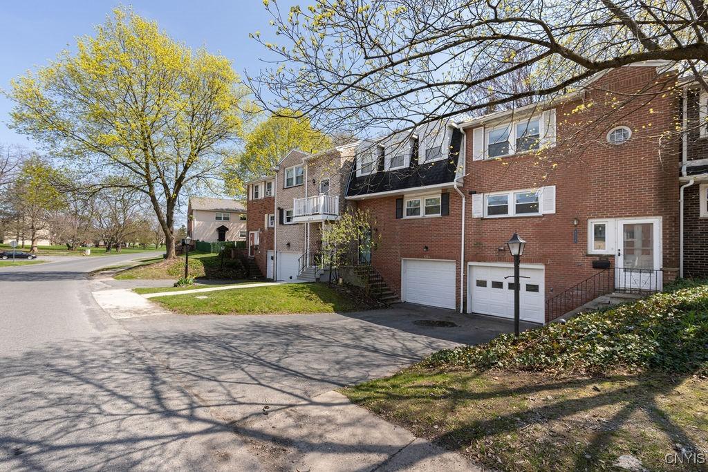 4314 Candlelight Ln, Clay, NY 13090 - exterior space with brick siding, an attached garage, aphalt driveway, and a residential view