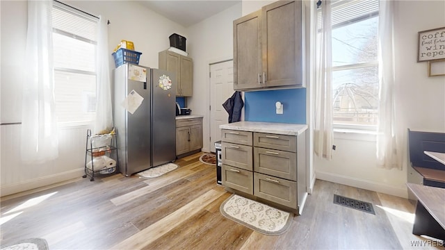 mudroom featuring light wood-style floors, visible vents, and baseboards