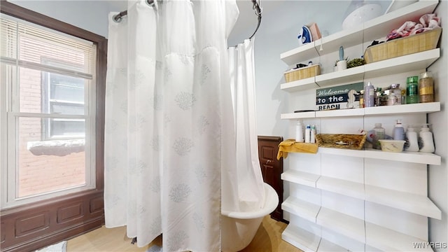 full bathroom featuring curtained shower and wood finished floors