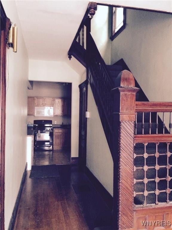 interior space with stairs, dark wood-type flooring, and baseboards