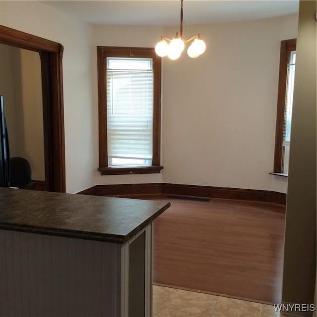 unfurnished dining area with a notable chandelier