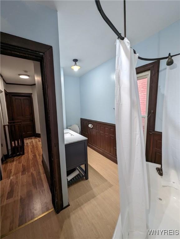 full bathroom with wood finished floors and a shower with shower curtain