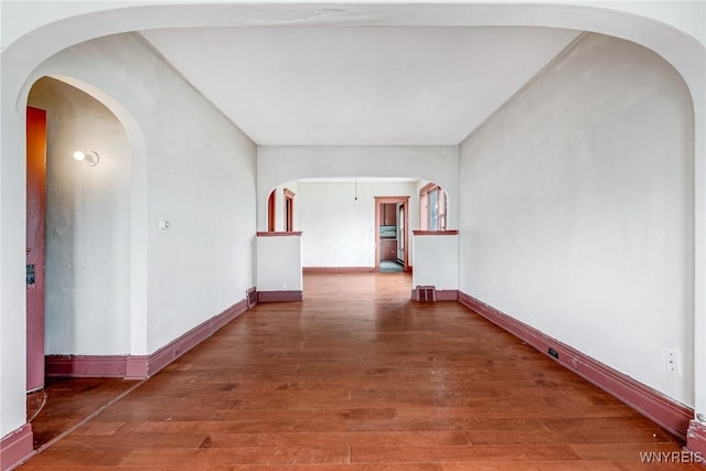 hallway with baseboards and wood finished floors