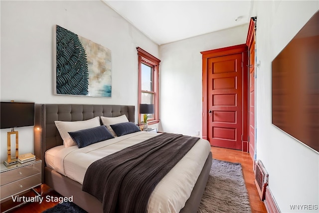 bedroom with wood finished floors and visible vents