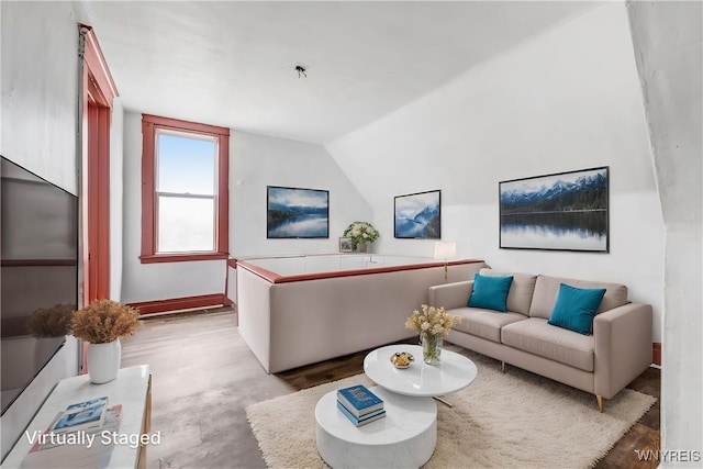 living room featuring vaulted ceiling and baseboards