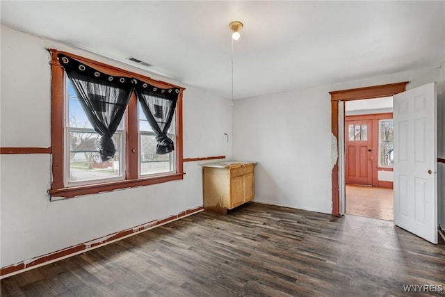 spare room with visible vents and dark wood finished floors