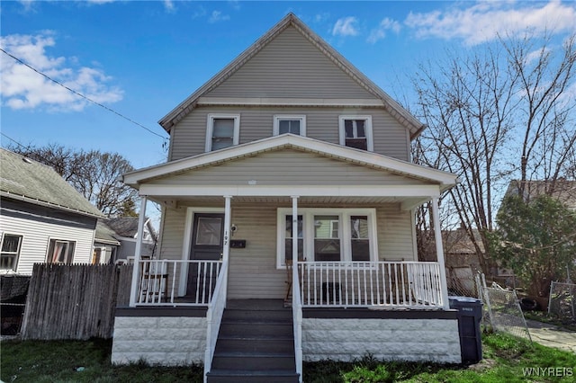 traditional style home featuring a porch and fence