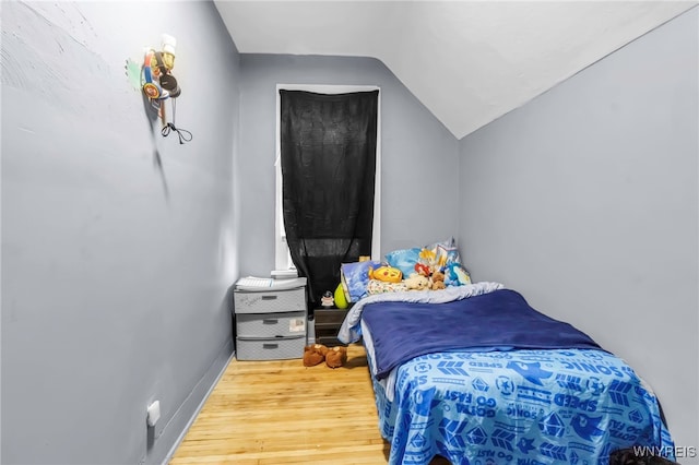 bedroom with lofted ceiling and wood finished floors