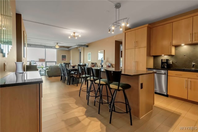 132 Lakefront Blvd Unit 504, Buffalo, NY 14202 - kitchen with dark countertops, stainless steel dishwasher, a sink, a kitchen island, and a kitchen bar