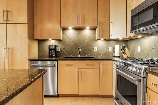 132 Lakefront Blvd Unit 504, Buffalo, NY 14202 - kitchen with stainless steel appliances, a sink, dark stone countertops, and tasteful backsplash