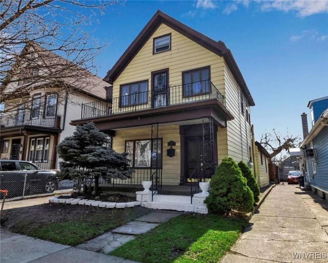 traditional home with covered porch and a balcony