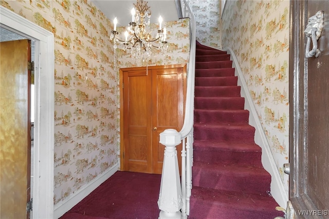 stairs featuring carpet, an inviting chandelier, wallpapered walls, and baseboards